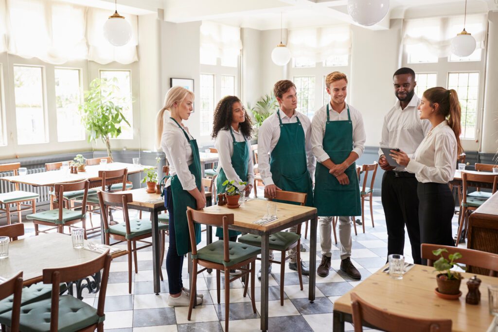 Staff Attending Team Meeting In Empty Dining Room